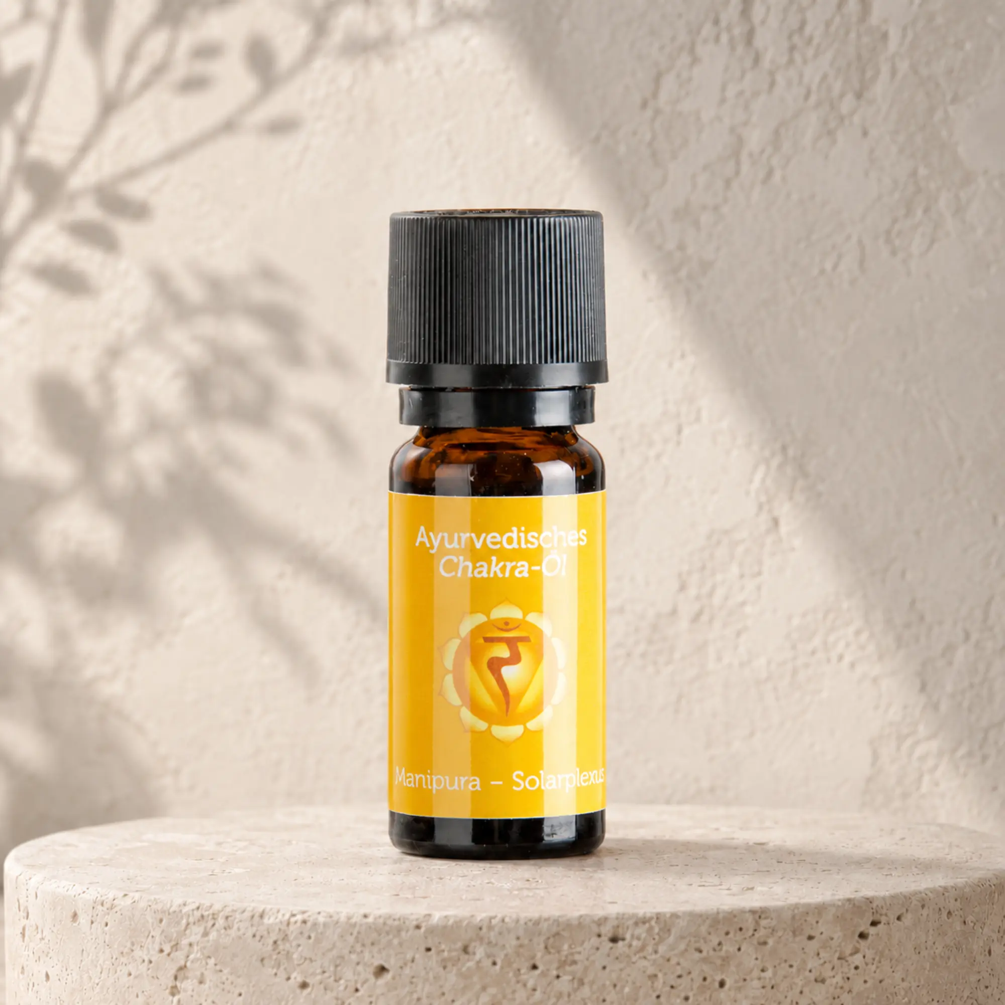 Berk ayurvedisches Chakra-Öl Manipura für das Solarplexuschakra auf hellem Steinpodest