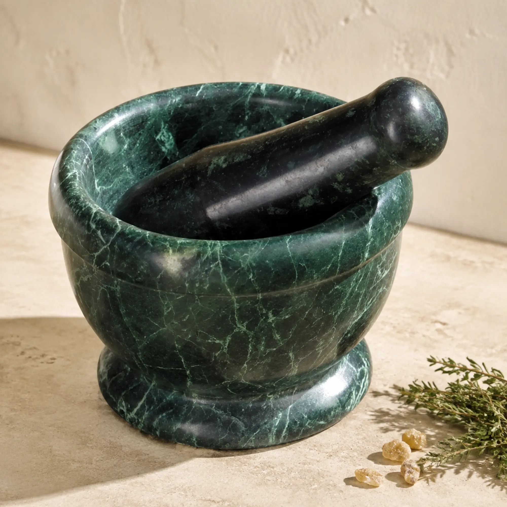 Dunkelgrüner Serpentinmörser mit Stößel, Kräutern und Räucherharz