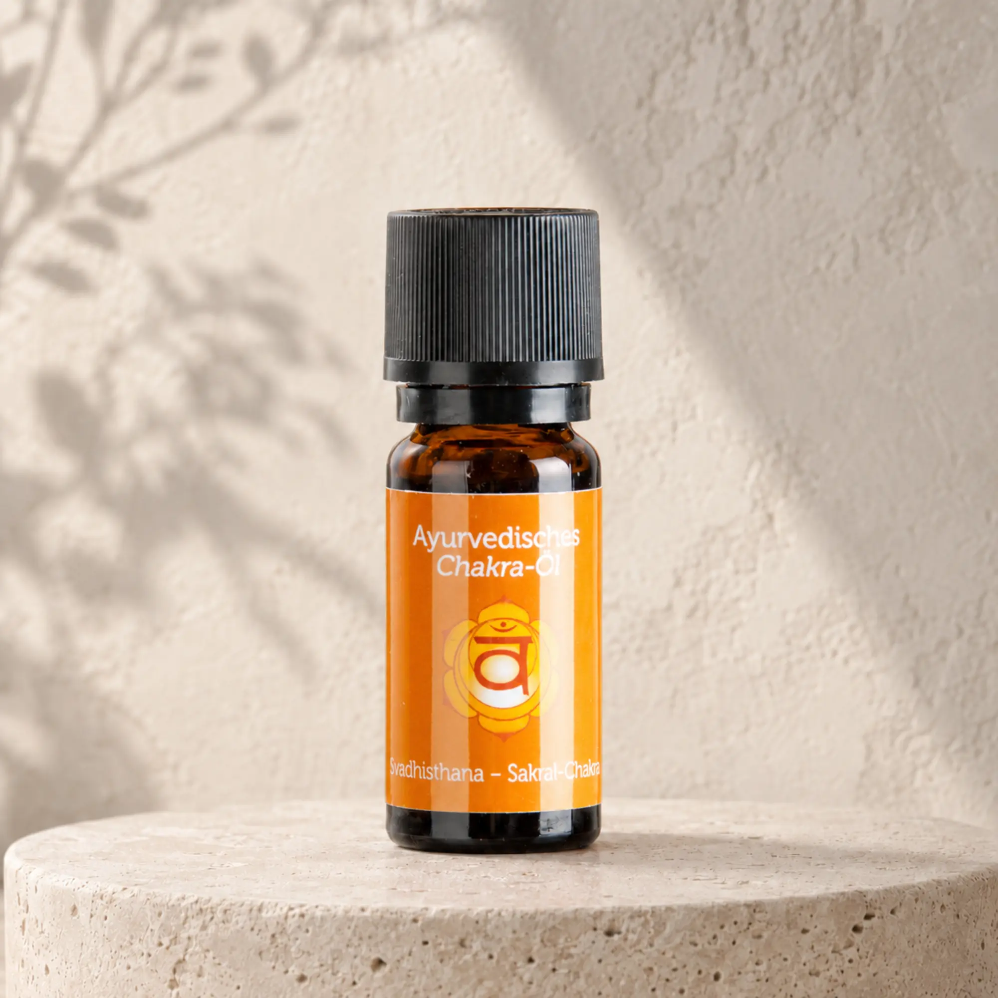 Berk ayurvedisches Chakra-Öl Svadhisthana für das Sakralchakra auf hellem Steinpodest