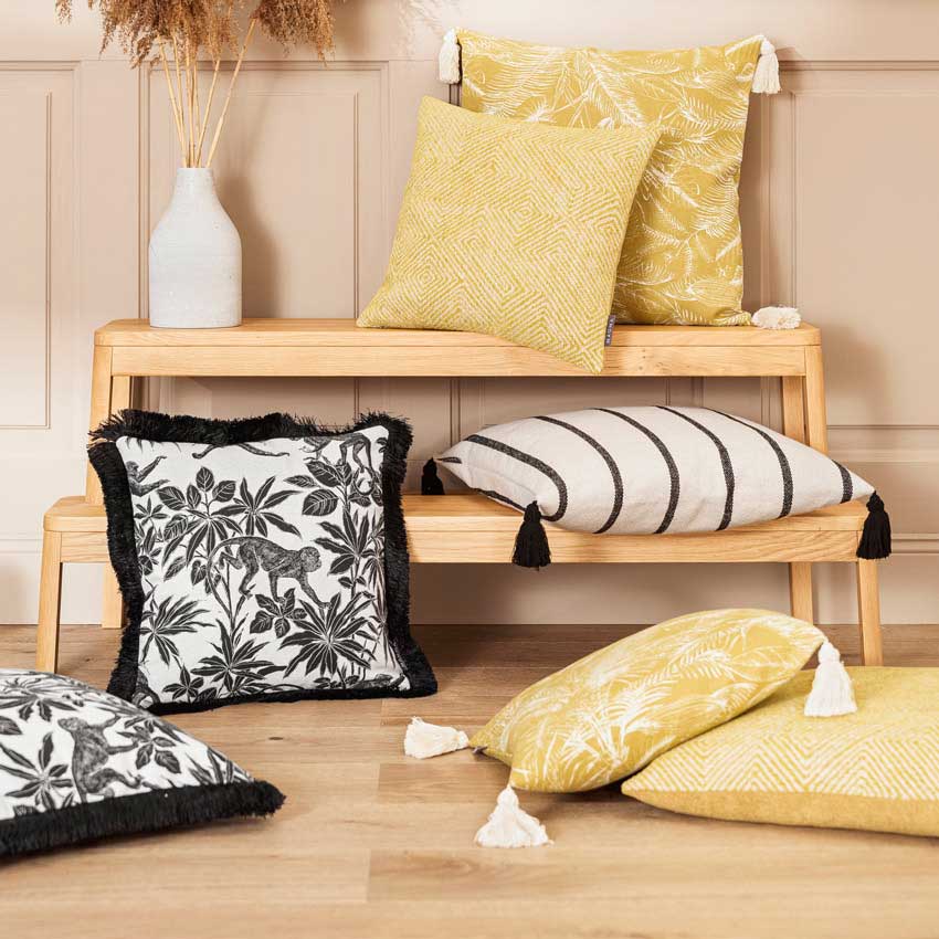 Magma Kissenserie „Jane & Oscar“ mit exotischen Mustern in Gelb, Schwarz und Weiß – stilvolle Kombination aus botanischen, grafischen und Tiermotiven mit Quasten.