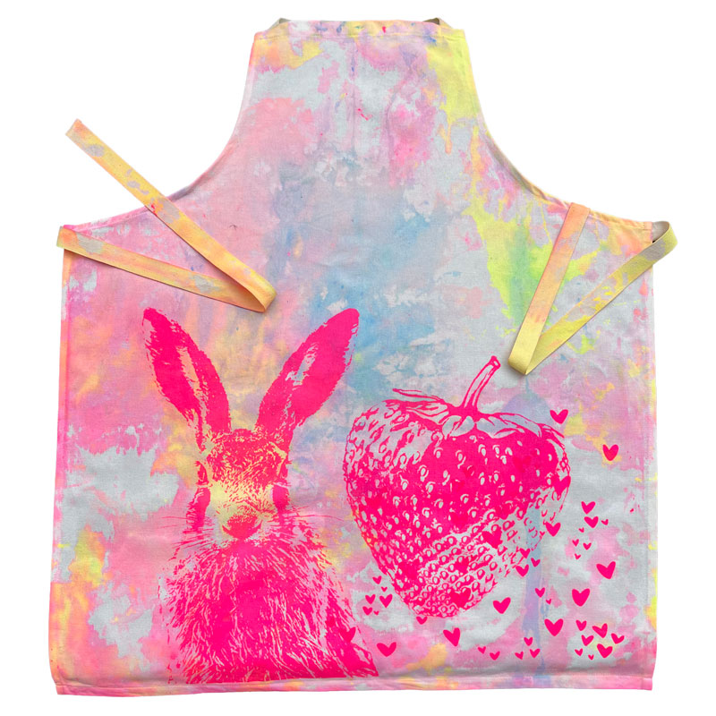 Frohstoff Schürze mit pinkfarbenem Hasen- und Erdbeermotiv auf buntem Hintergrund – handbedruckte Leinenschürze im fröhlichen Design für Küche und Garten.