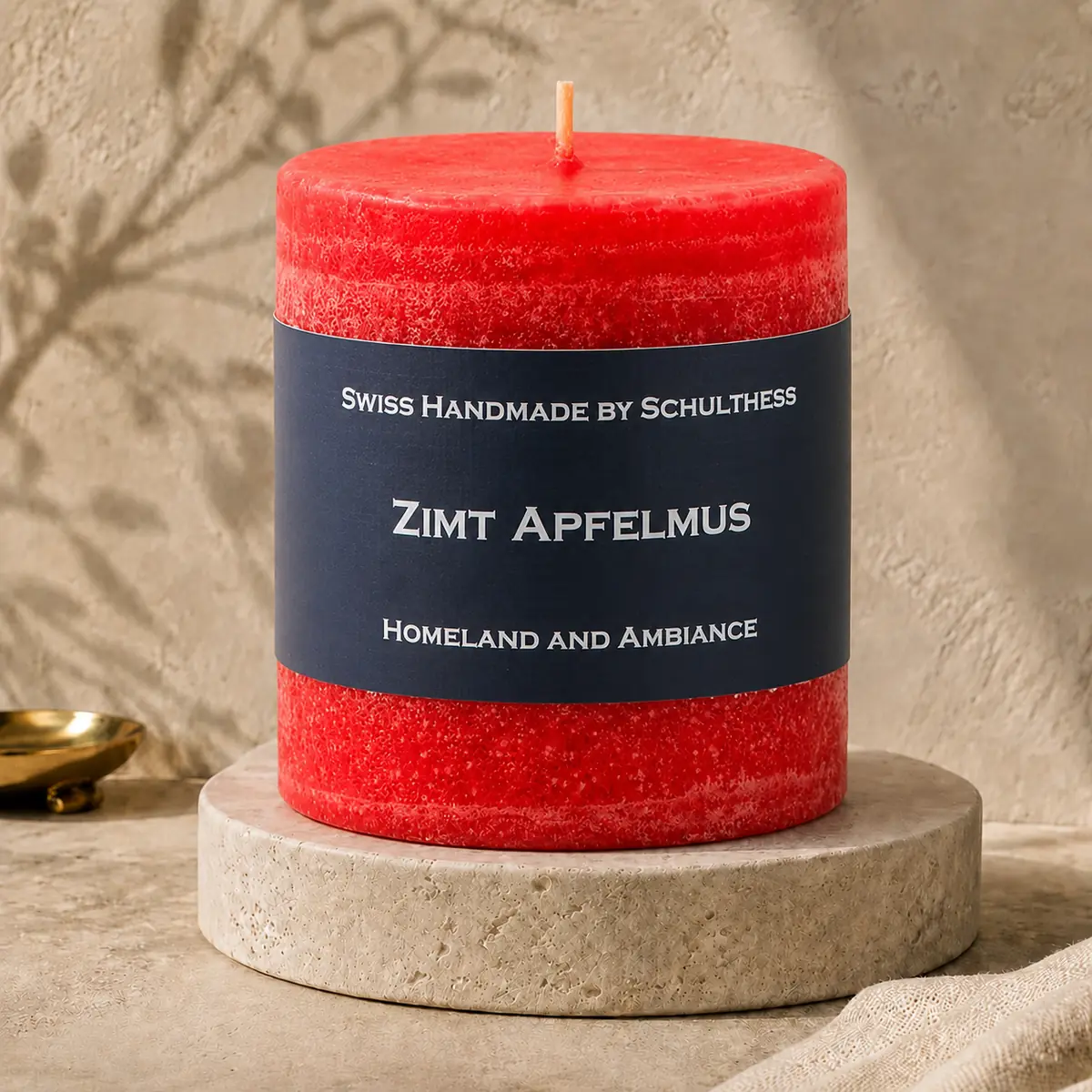 Schulthess Duftkerze Zimt Apfelmus auf einem Travertinteller