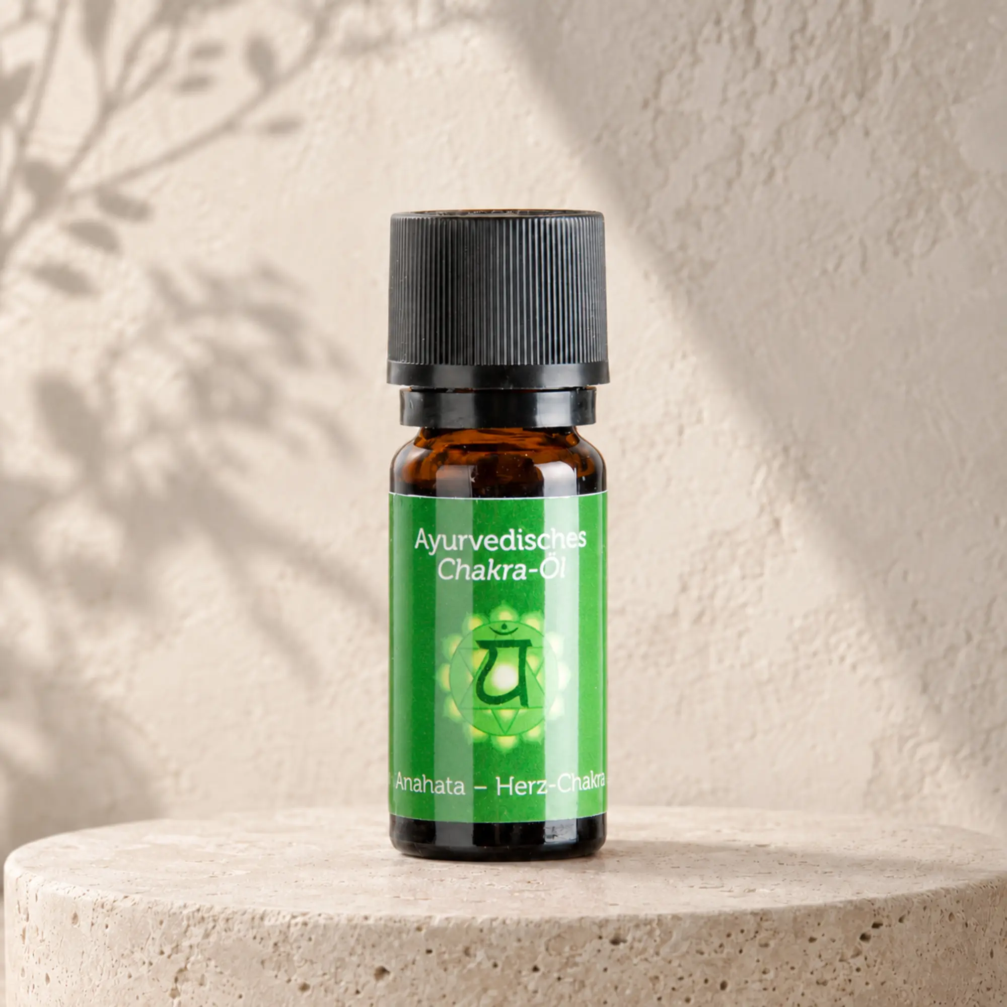 Berk ayurvedisches Chakra-Öl Anahata für das Herzchakra auf hellem Steinpodest