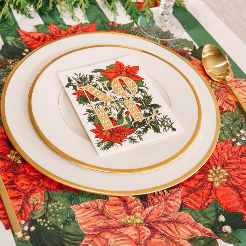 Festliche Tischdekoration von Hester & Cook mit Weihnachtsmotiv aus roten Weihnachtssternen, goldenen Akzenten und stilvoller Papeterie – elegante Deko für die Feiertage.