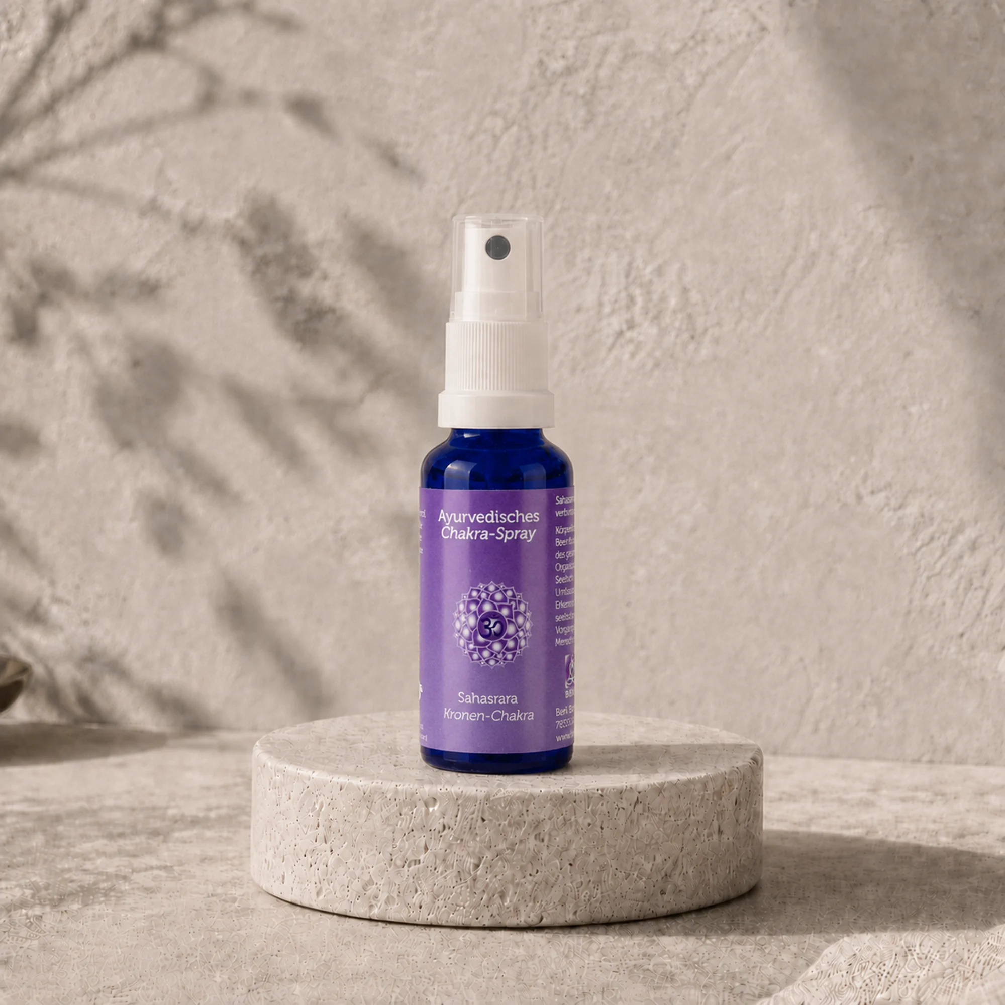 Berk Chakra-Spray Sahasrara für das Kronen-Chakra auf einem runden Travertinpodest.