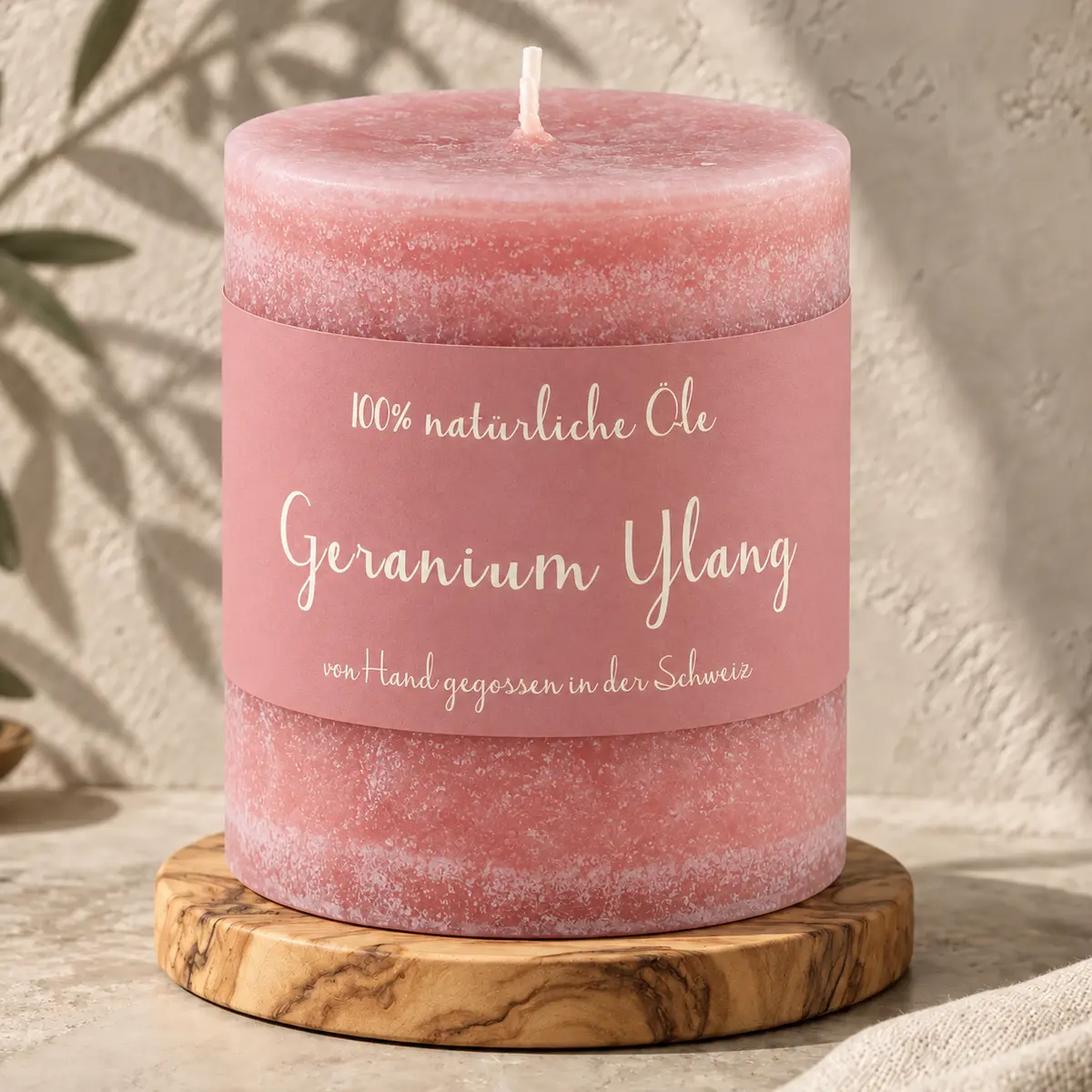 Rosafarbene Schulthess Duftkerze Geranium Ylang aus 100 % natürlichen Ölen auf einem Holzsockel
