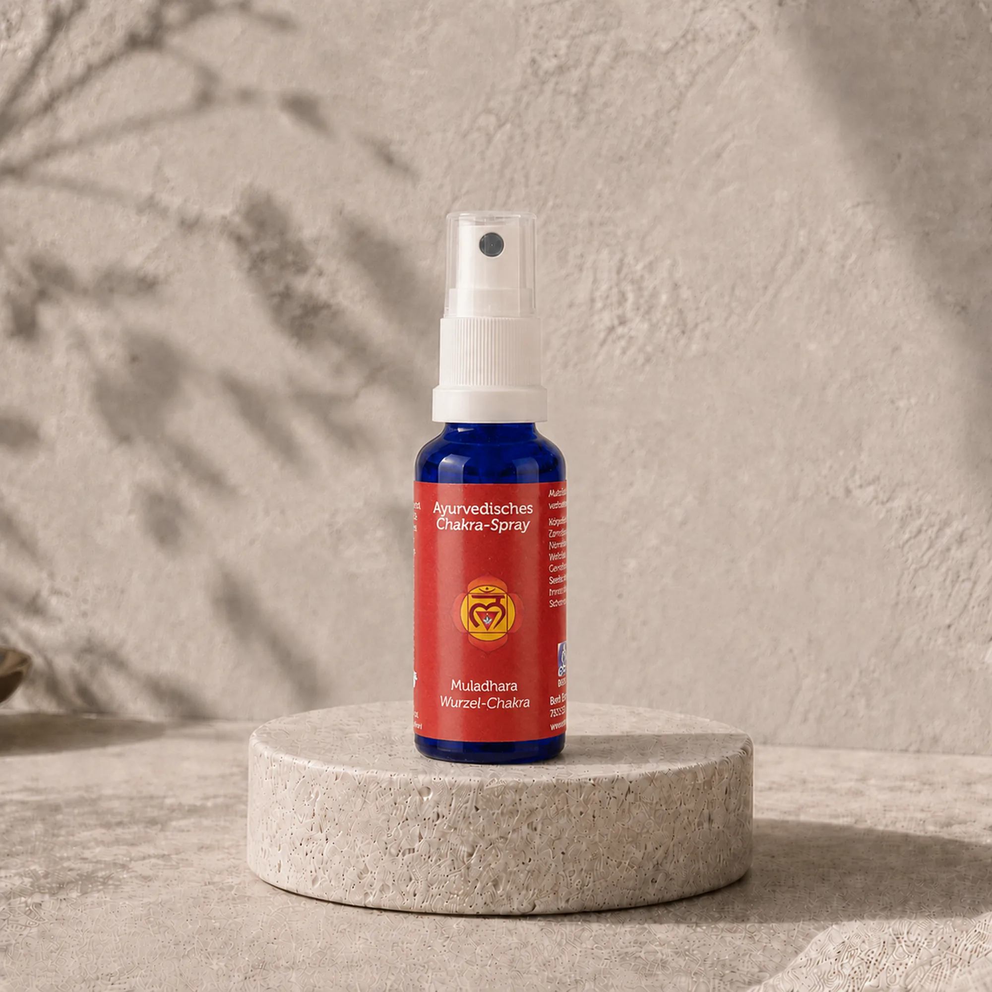 Berk Chakra-Spray Muladhara für das Wurzel-Chakra auf einem runden Travertinpodest.