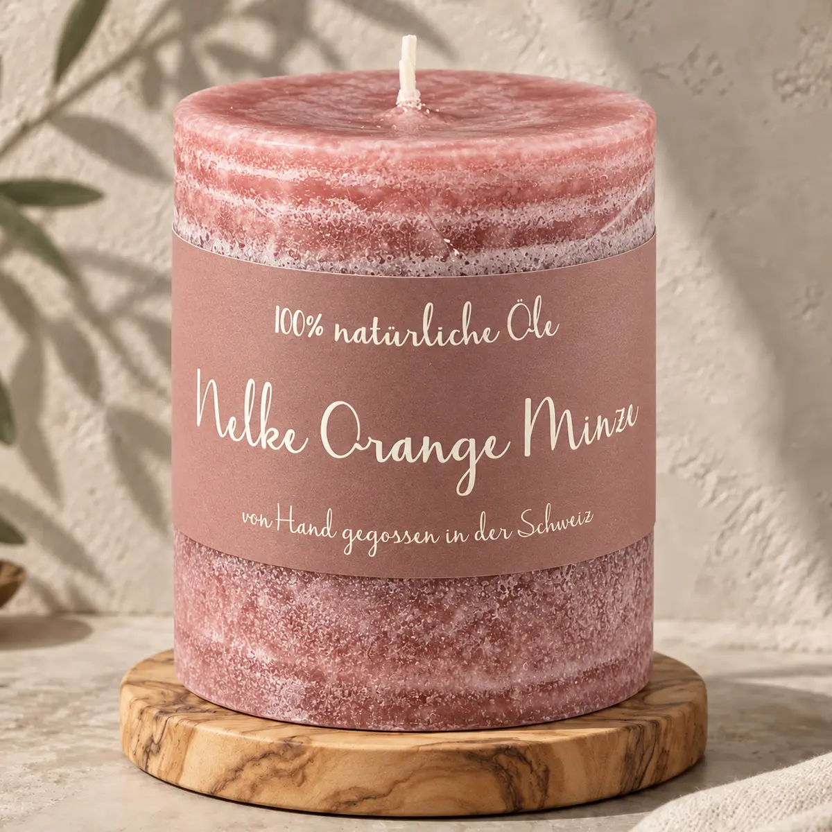 Altrosafarbene Schulthess Duftkerze Nelke Orange Minze aus 100 % natürlichen Ölen auf einem Holzsockel