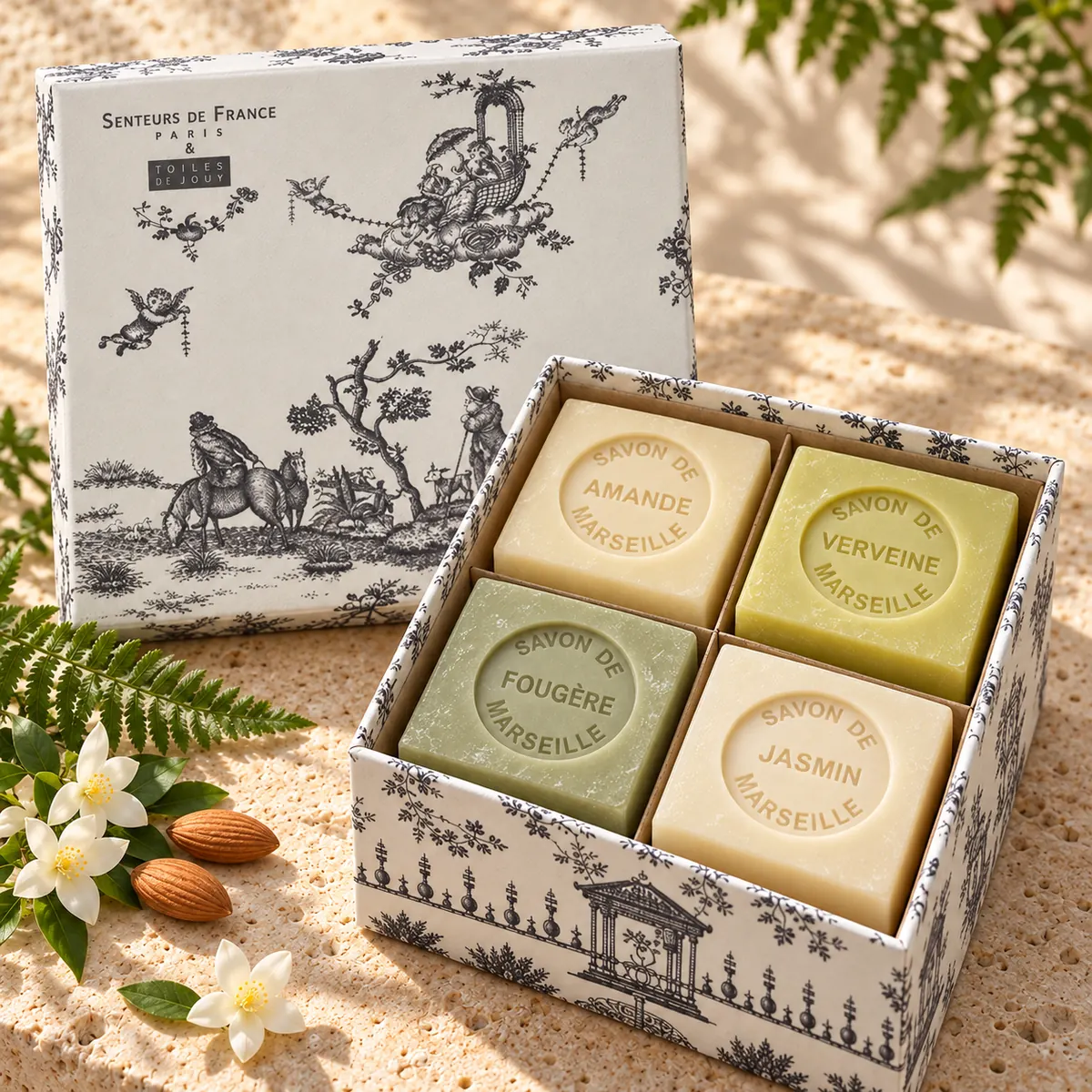 Senteurs de France Seifenset mit Amande, Verveine, Fougère und Jasmin in grauer Toile-de-Jouy-Geschenkbox auf Travertin.