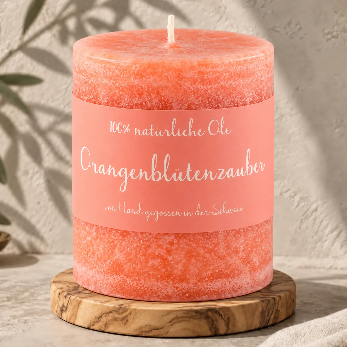 Korallfarbene Schulthess Duftkerze Orangenblütenzauber aus 100 % natürlichen Ölen auf einem Holzsockel
