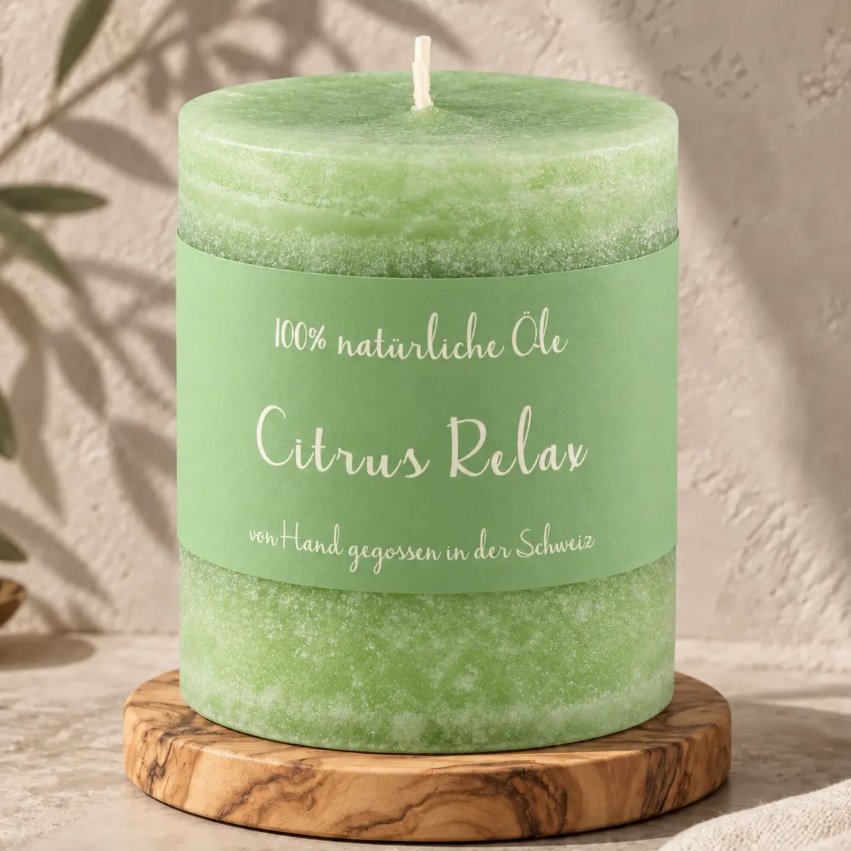 Grüne Schulthess Duftkerze Citrus Relax aus 100 % natürlichen Ölen auf einem Holzsockel