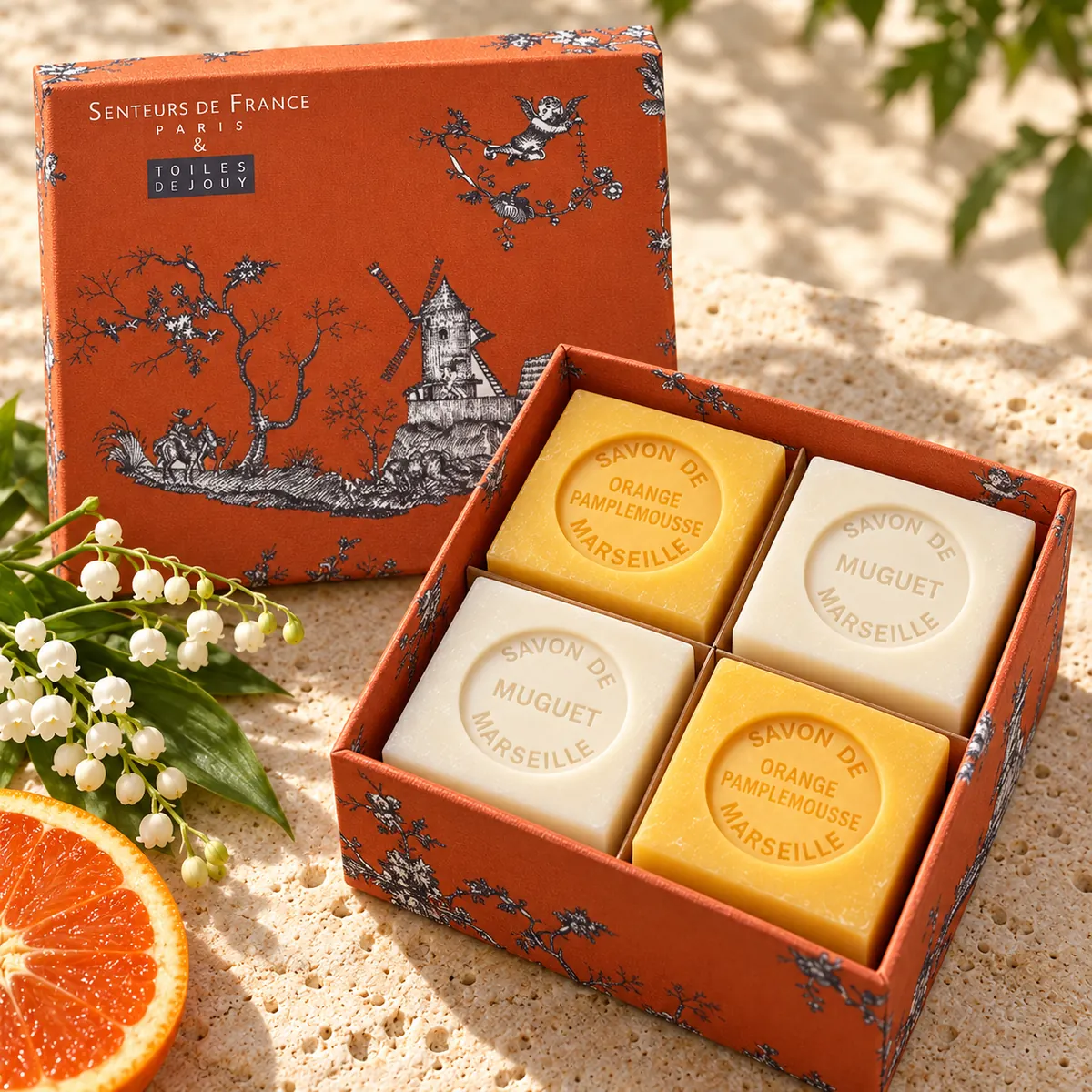 Senteurs de France Seifenset mit je zwei Würfelseifen Muguet und Orange Pamplemousse in orangefarbener Toile-de-Jouy-Geschenkbox.