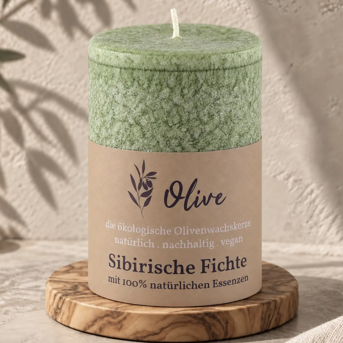 Schulthess Olivenwachskerze Sibirische Fichte auf einem runden Holzteller