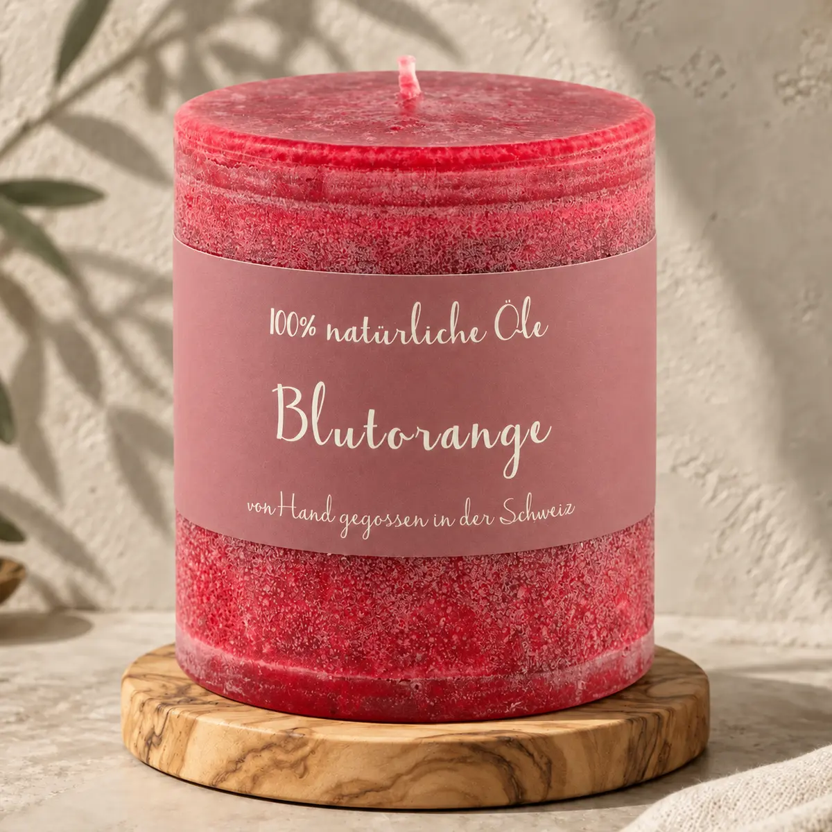 Dunkelrote Schulthess Duftkerze Blutorange aus 100 % natürlichen Ölen auf einem Holzsockel