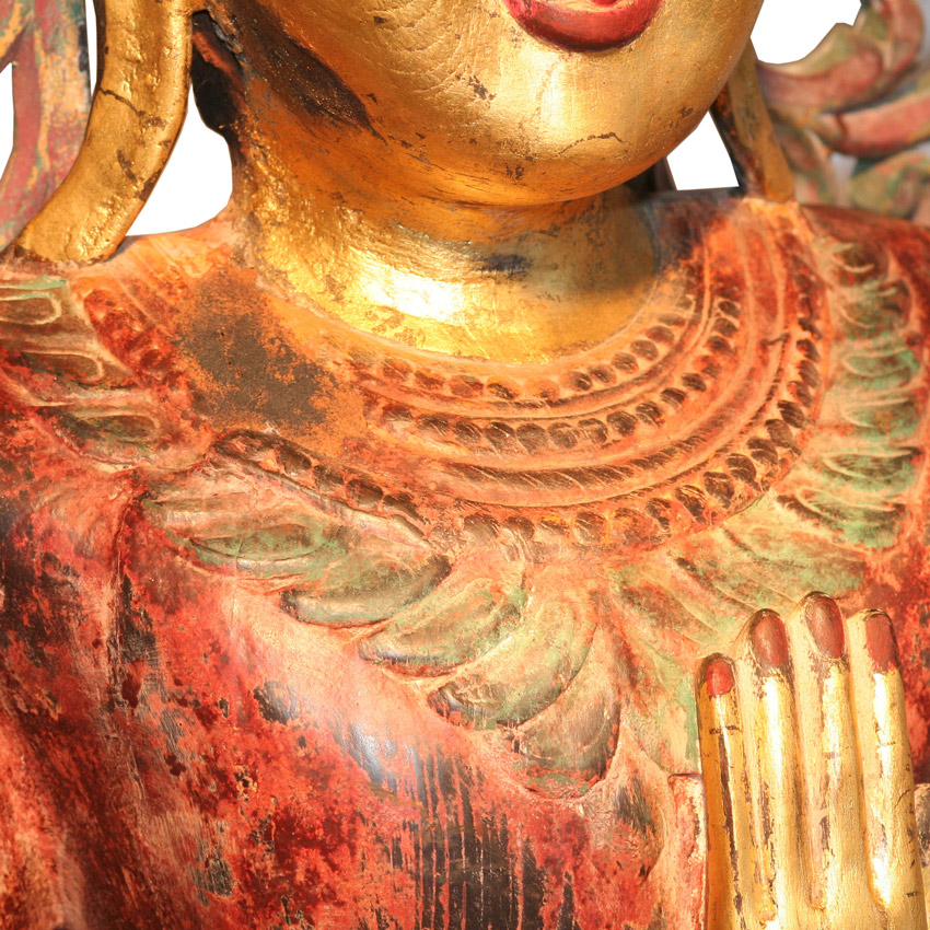 Detailansicht des großen burmesischen Königsbuddha, fein geschnitzte Krone und vergoldetes Gesicht mit roter Patina, traditionelles Kunsthandwerk.