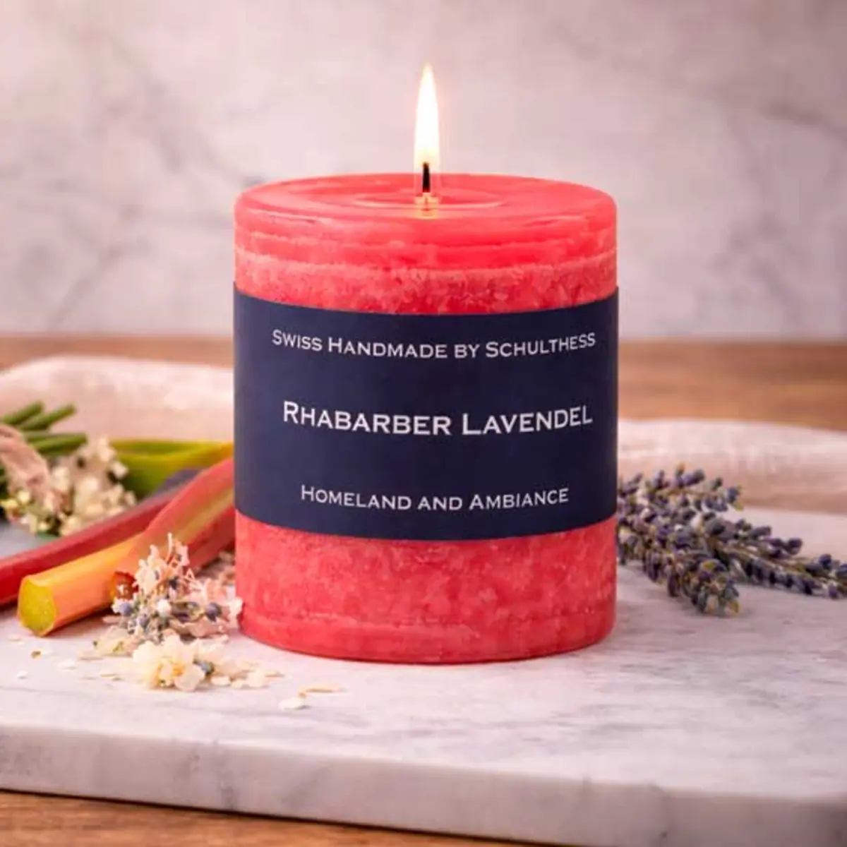 Brennende Schulthess Duftkerze Rhabarber Lavendel mit Rhabarberstangen und Lavendelblüten