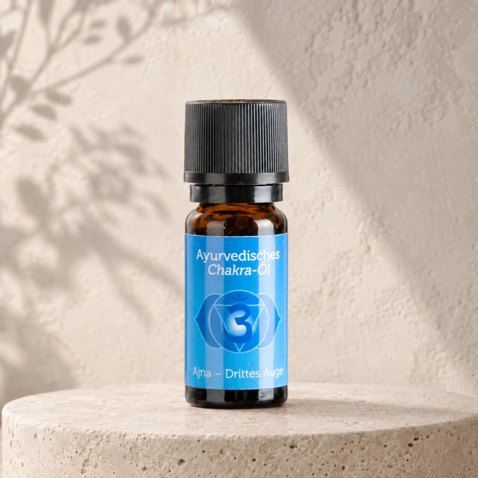 Berk ayurvedisches Chakra-Öl Ajna für das dritte Auge auf hellem Steinpodest