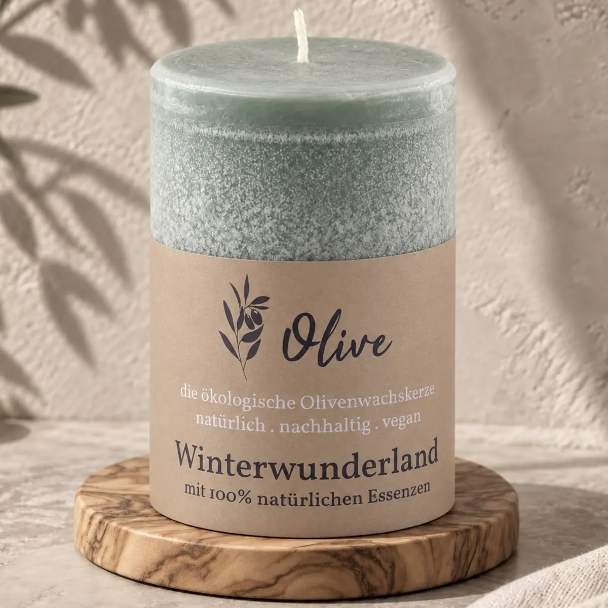 Schulthess Olivenwachskerze Winterwunderland auf einem runden Holzteller