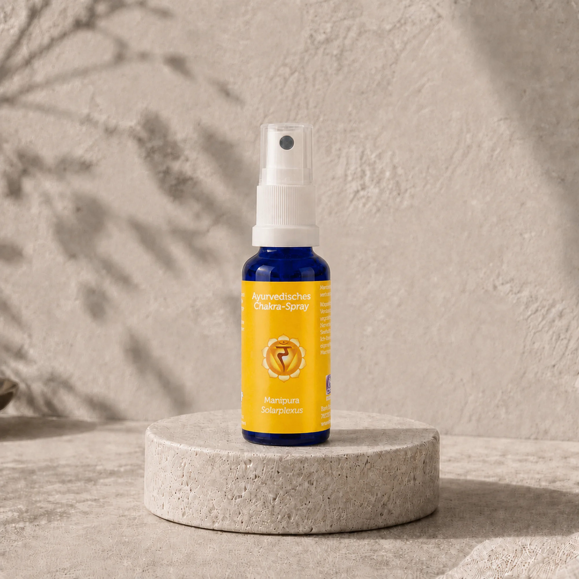 Berk Chakra-Spray Manipura für den Solarplexus auf einem runden Travertinpodest.