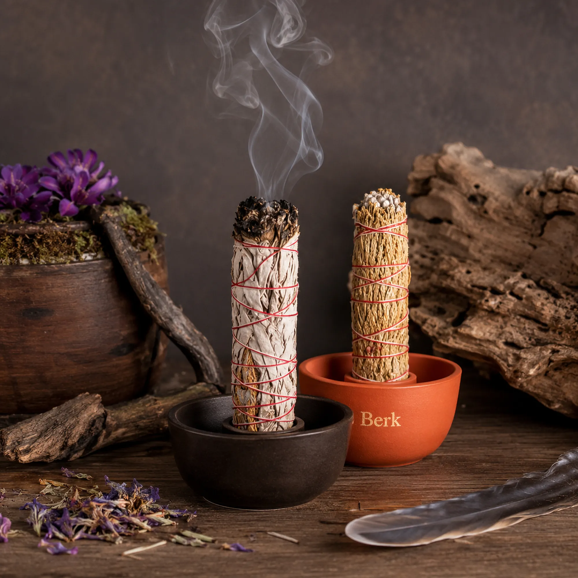 Indianische Smudge Sticks und heimische Kräuterbündel von BERK in Räucherschalen mit aufsteigendem Rauch auf einem rustikalen Holztisch