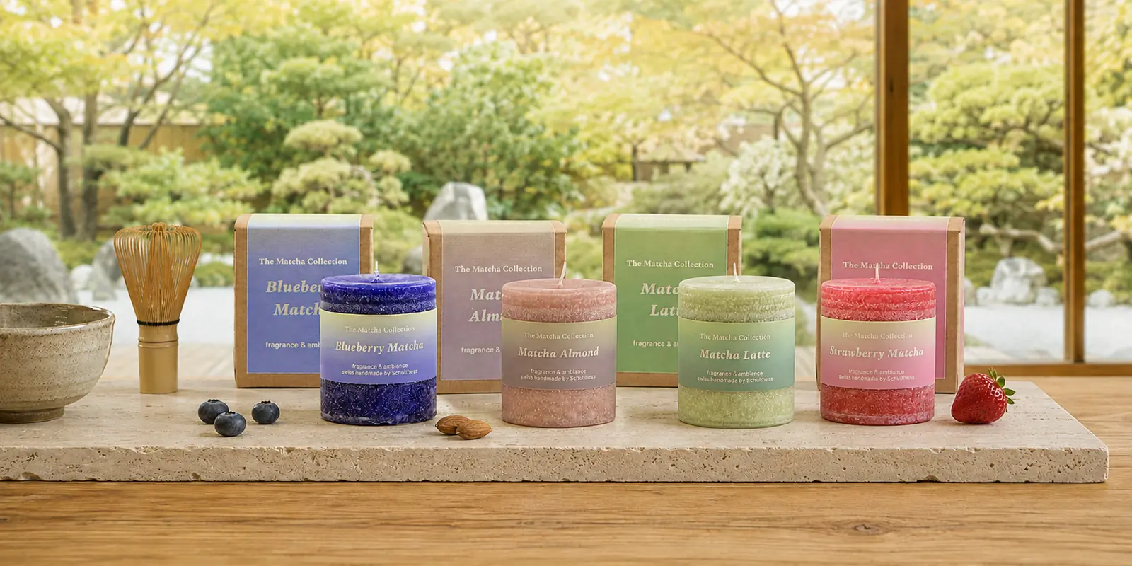Vier Schulthess Matcha Duftkerzen mit Verpackungen vor einem japanischen Garten