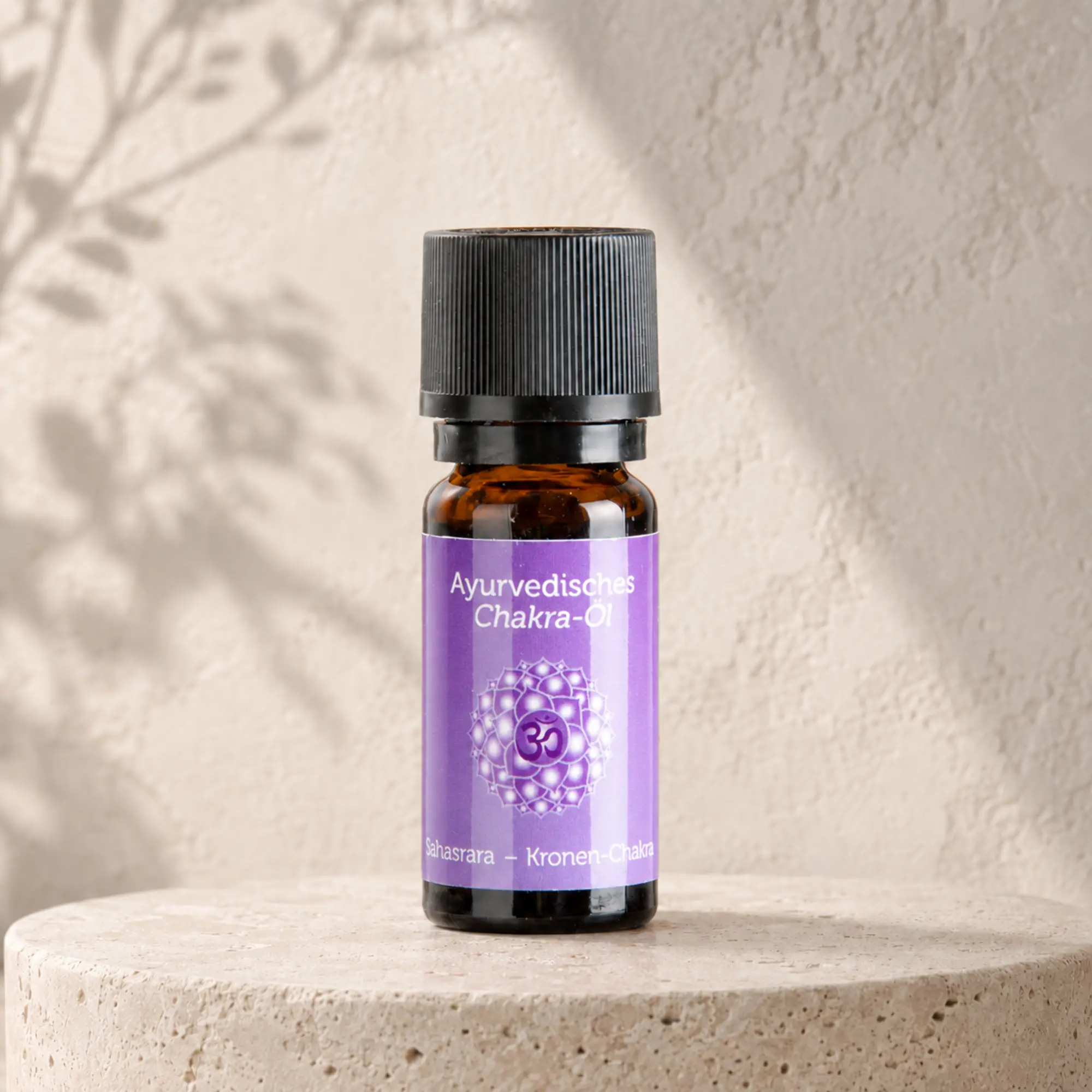Berk ayurvedisches Chakra-Öl Sahasrara für das Kronenchakra auf hellem Steinpodest