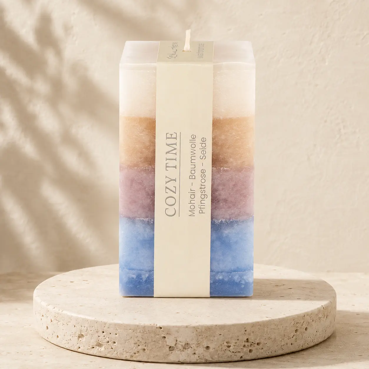 Eckige Schulthess Duftkerze Cozy Time Quadro in Creme, Beige, Mauve und Blau auf Travertin