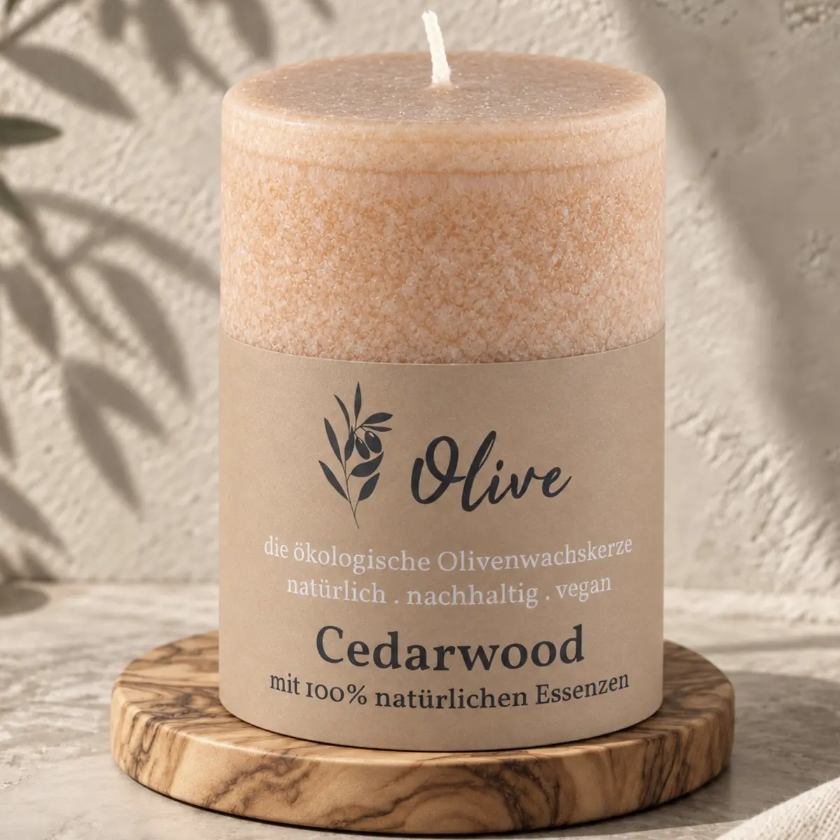 Schulthess Olivenwachskerze Cedarwood auf einem runden Holzteller