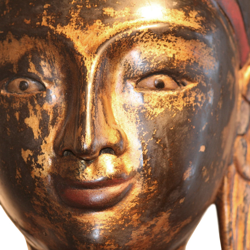 Detailansicht des Gesichts eines großen roten Buddha, vergoldete Patina mit feinen Altersspuren, ruhiger Ausdruck und burmesische Handwerkskunst.