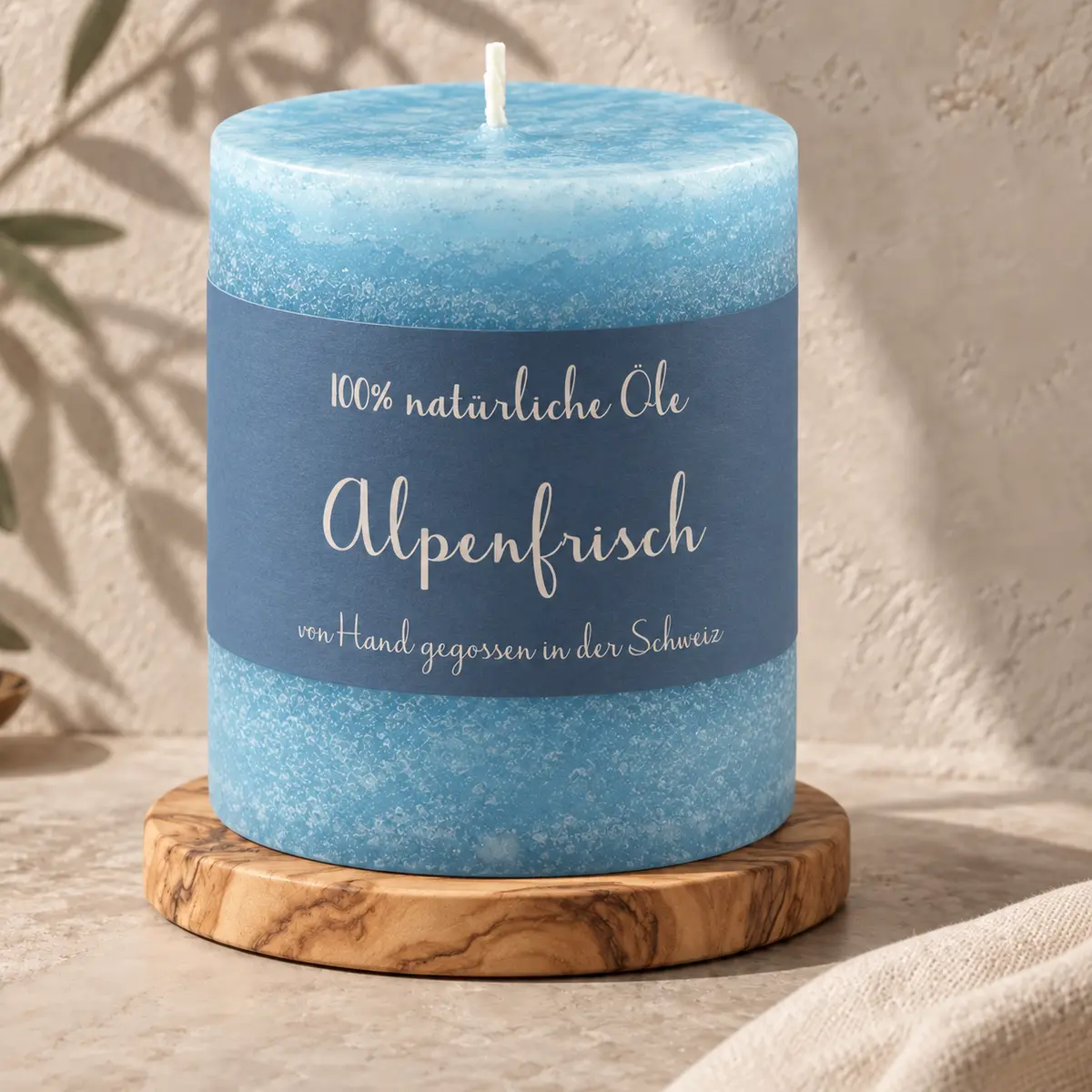 Blaue Schulthess Duftkerze Alpenfrisch aus 100 % natürlichen Ölen auf einem Holzsockel