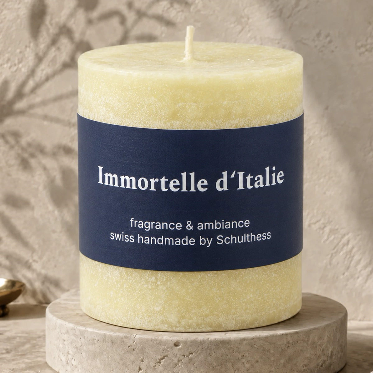 Schulthess Duftkerze Immortelle d’Italie auf einem hellen Travertinsockel