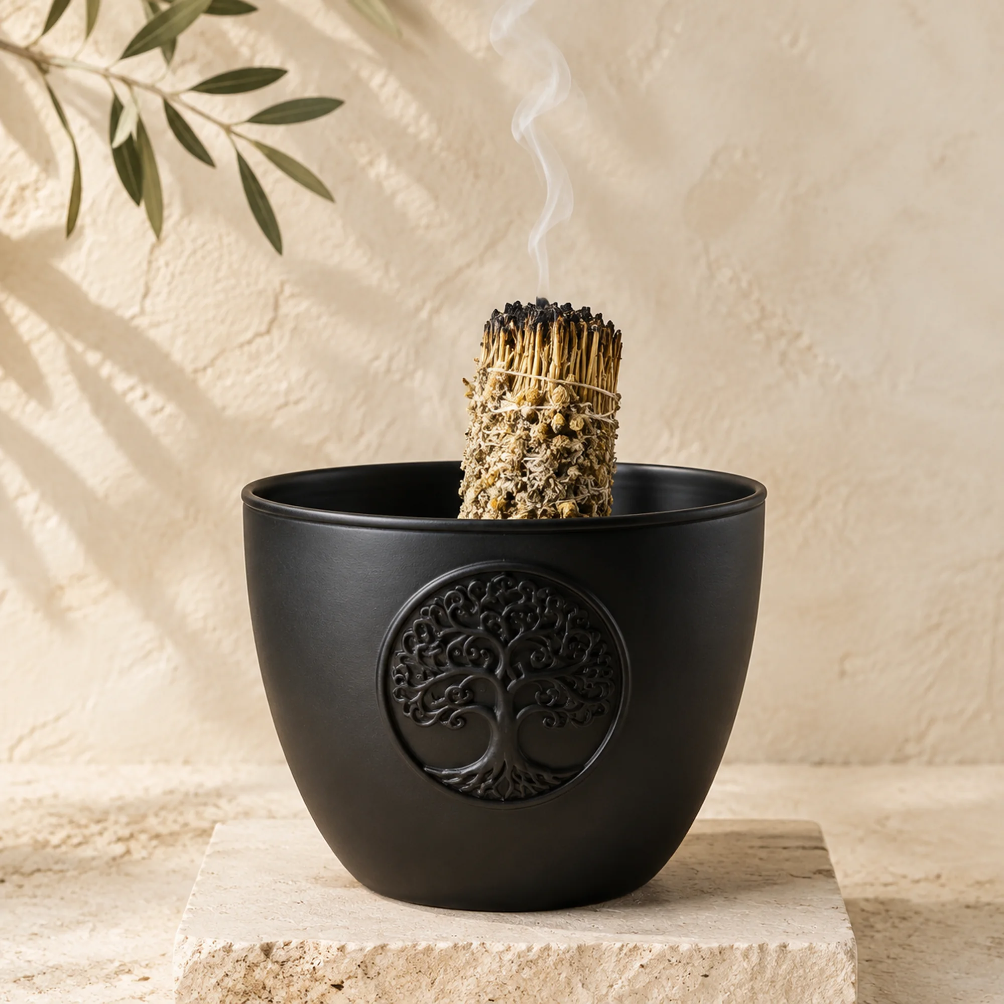 Schwarze Berk Smudge Bowl mit Lebensbaum und glimmendem Räucherbündel auf hellem Naturstein