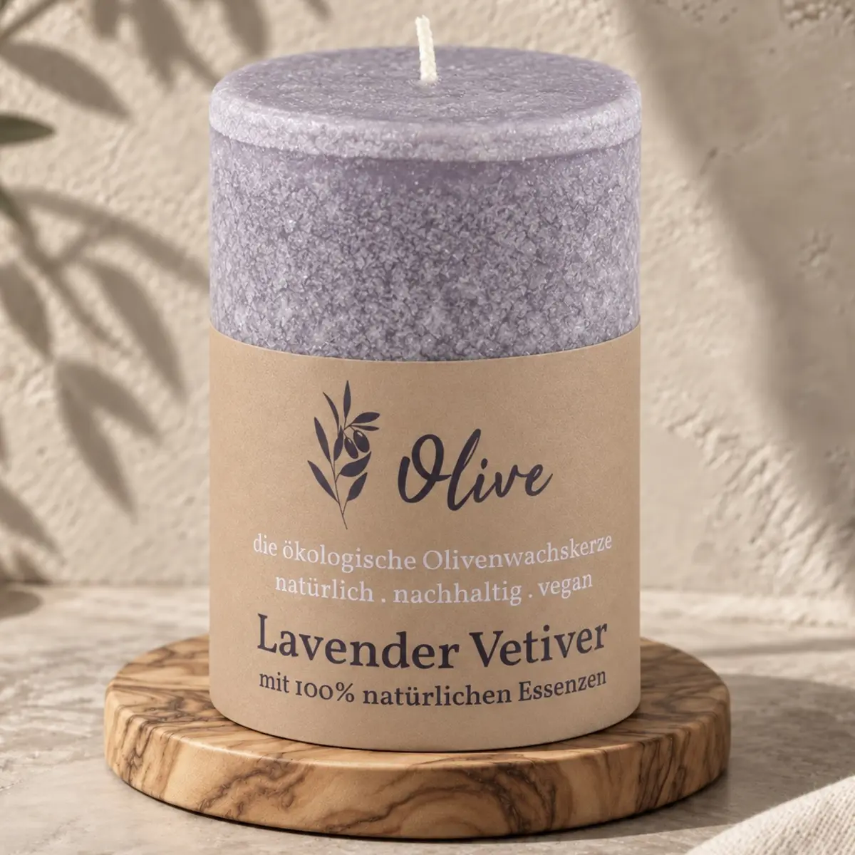 Schulthess Olivenwachskerze Lavendel & Vetiver auf einem runden Holzteller