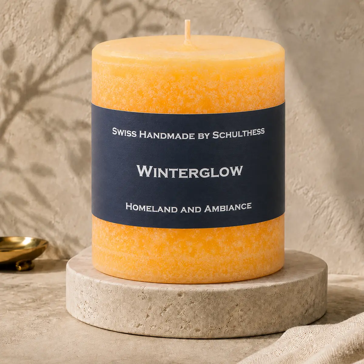 Schulthess Duftkerze Winterglow auf einem Travertinteller
