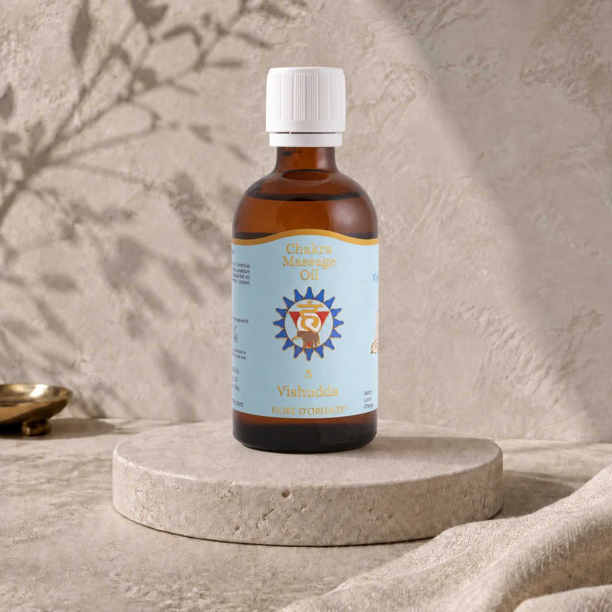 Vishudda Kehl-Chakra Massageöl von Berk, 100 ml, auf hellem Travertin-Podest