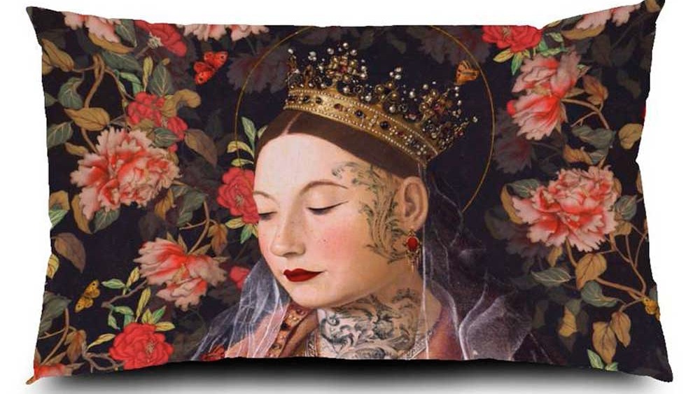 Voglio Bene Samtkissen Messina 40x65 – kunstvolles Porträt einer jungen Frau mit goldener Krone, Tattoos und geschlossenen Augen, umgeben von opulenten Rosen auf dunklem Hintergrund.