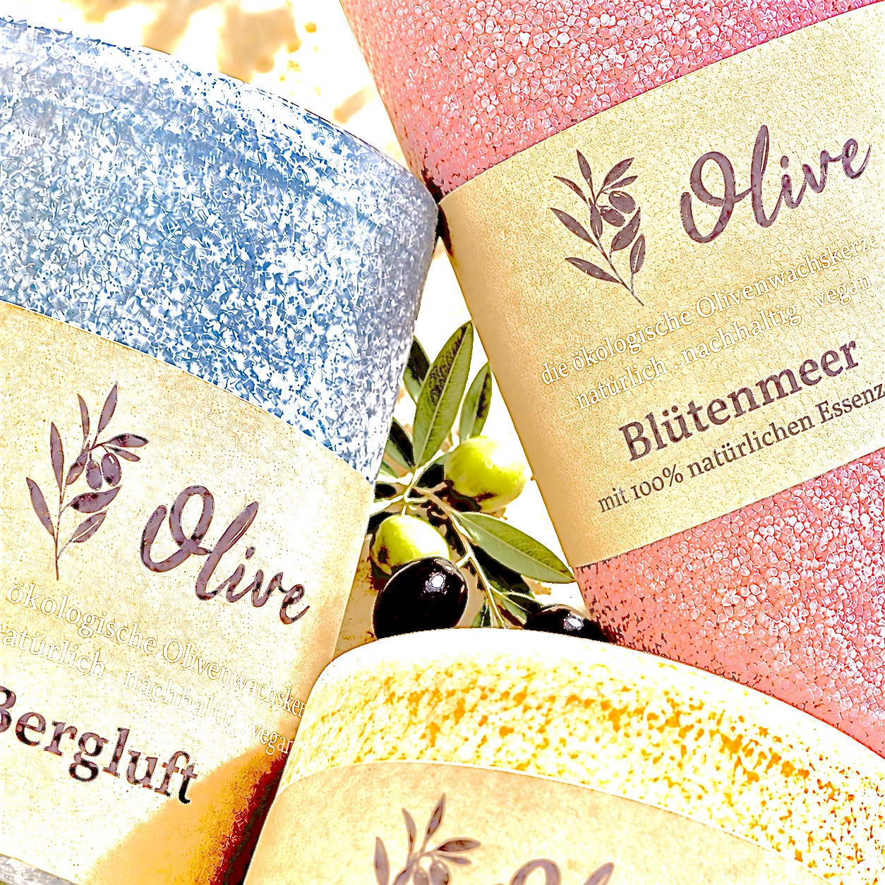 Schulthess Olivenwachskerzen mit 100 % natürlichen Essenzen in Bergluft, Blütenmeer und weiteren Duftvarianten mit Olivenzweig im Detail.