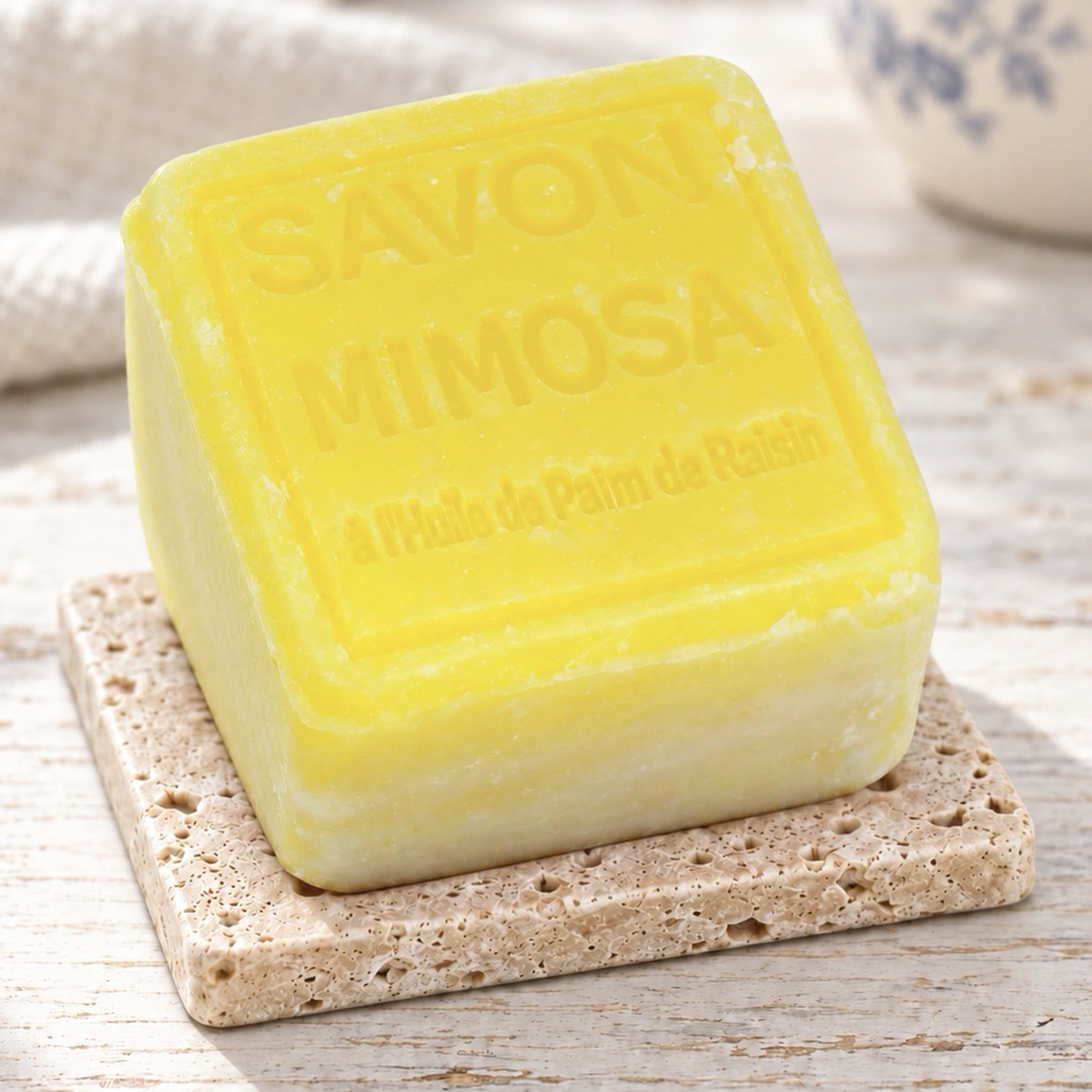 Gelber Maitre Savonitto Seifenwürfel Mimosa auf Travertin