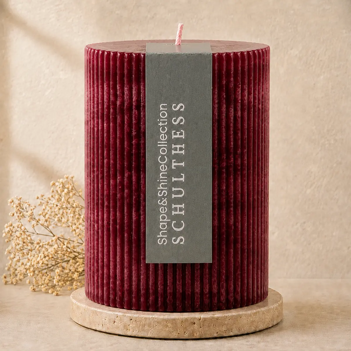 Schulthess Shape & Shine Kerze Bordeaux ohne Duft auf Travertinteller