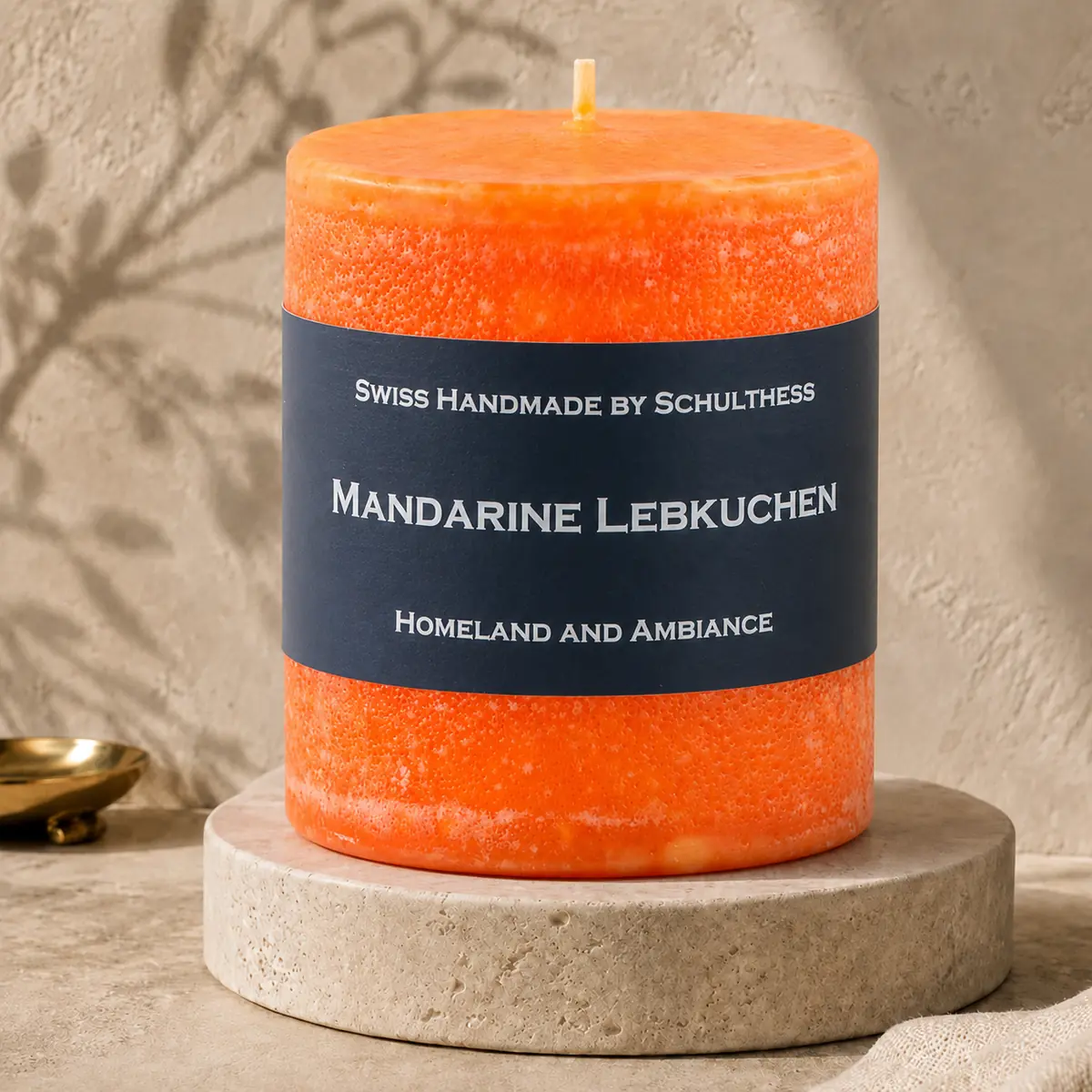 Schulthess Duftkerze Mandarine Lebkuchen auf einem Travertinteller