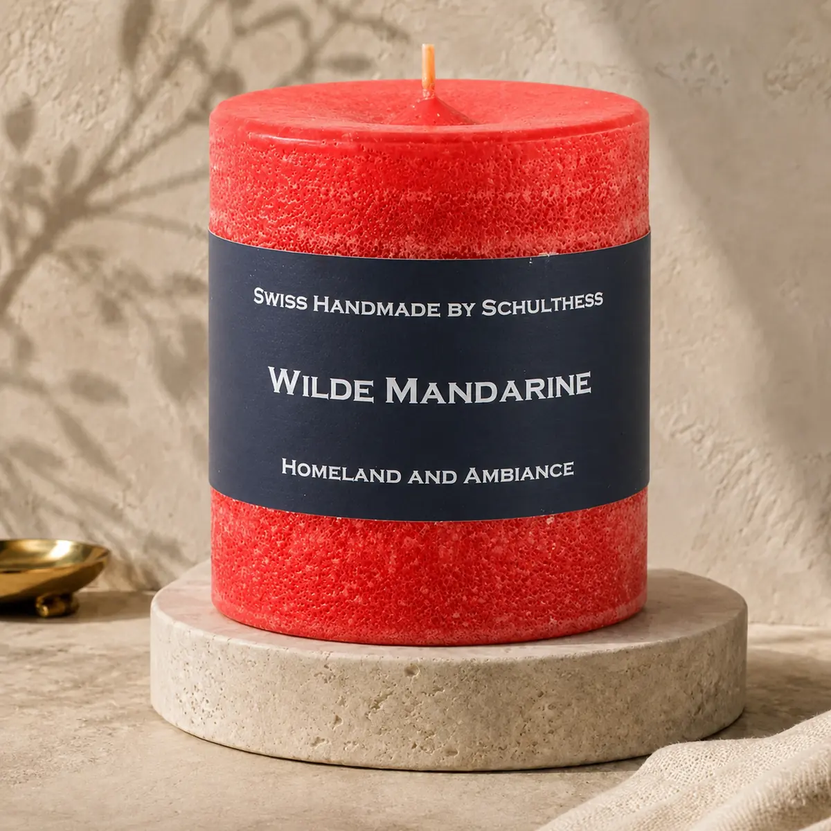 Schulthess Duftkerze Wilde Mandarine auf einem Travertinteller