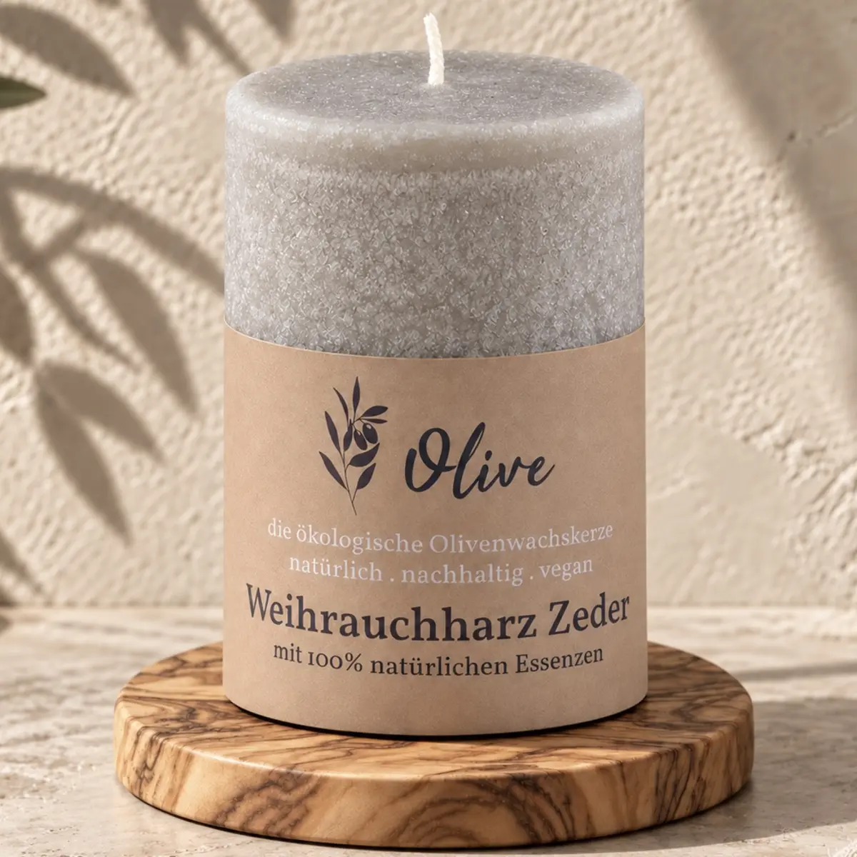 Schulthess Olivenwachskerze Weihrauchharz & Zeder auf einem runden Holzteller