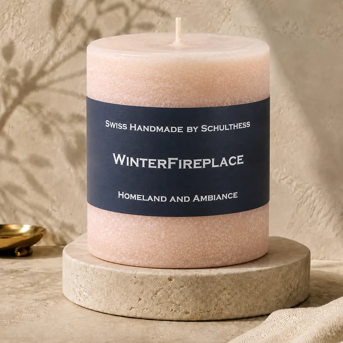 Schulthess Duftkerze Winterfireplace auf einem Travertinteller