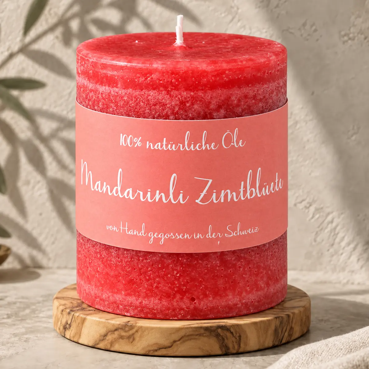 Rote Schulthess Duftkerze Mandarinli Zimtblüte aus 100 % natürlichen Ölen auf einem Holzsockel