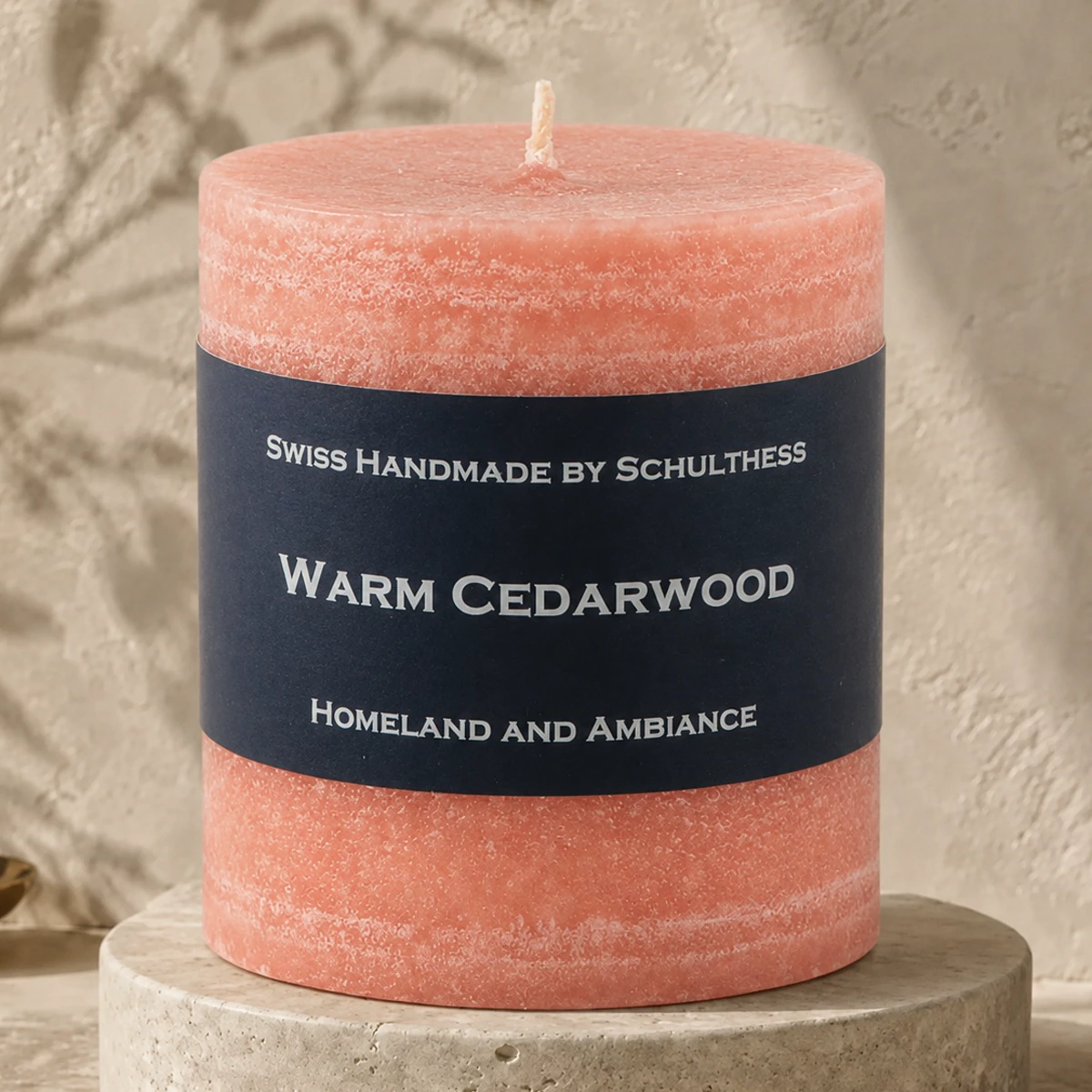 Schulthess Duftkerze Warm Cedarwood auf einem hellen Travertinsockel
