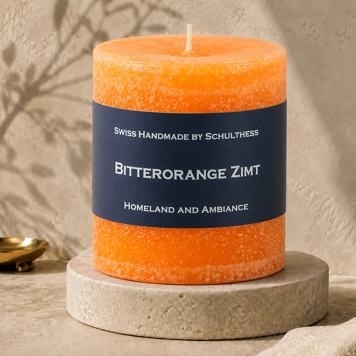 Schulthess Duftkerze Bitterorange Zimt auf einem Travertinteller