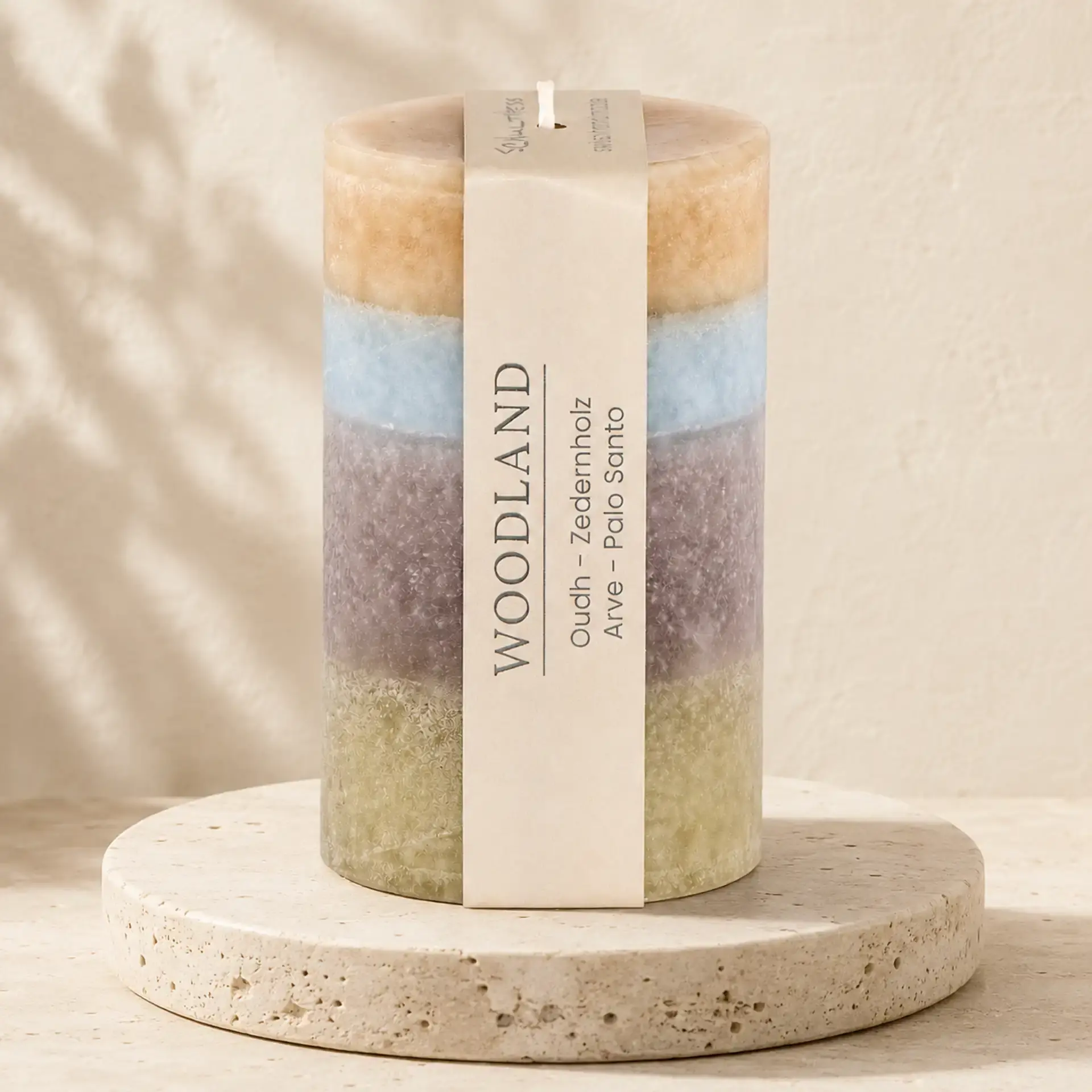 Runde Schulthess Duftkerze Woodland in Beige, Hellblau, Mauve und Olivgrün auf Travertin