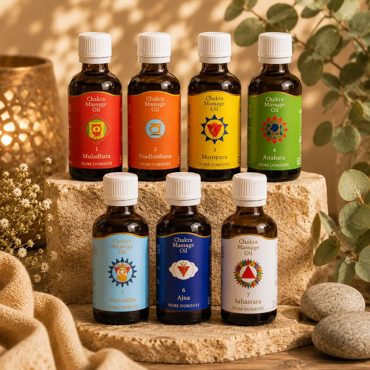 Sieben Chakra Massageöle von Berk als farbenfrohe Gruppe auf Naturstein