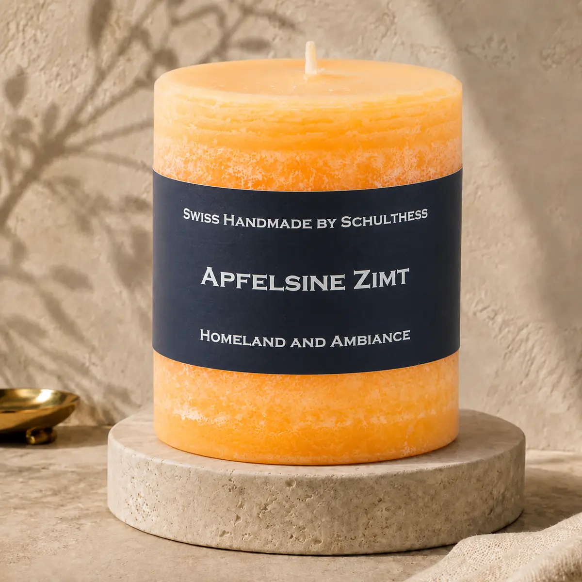 Schulthess Duftkerze Apfelsine Zimt auf einem Travertinteller