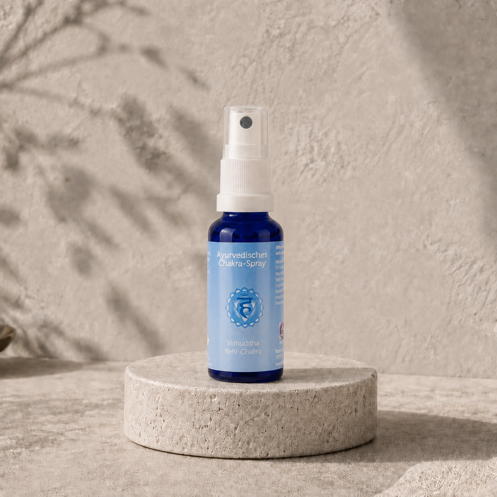 Berk Chakra-Spray Vishuddha für das Kehl-Chakra auf einem runden Travertinpodest.